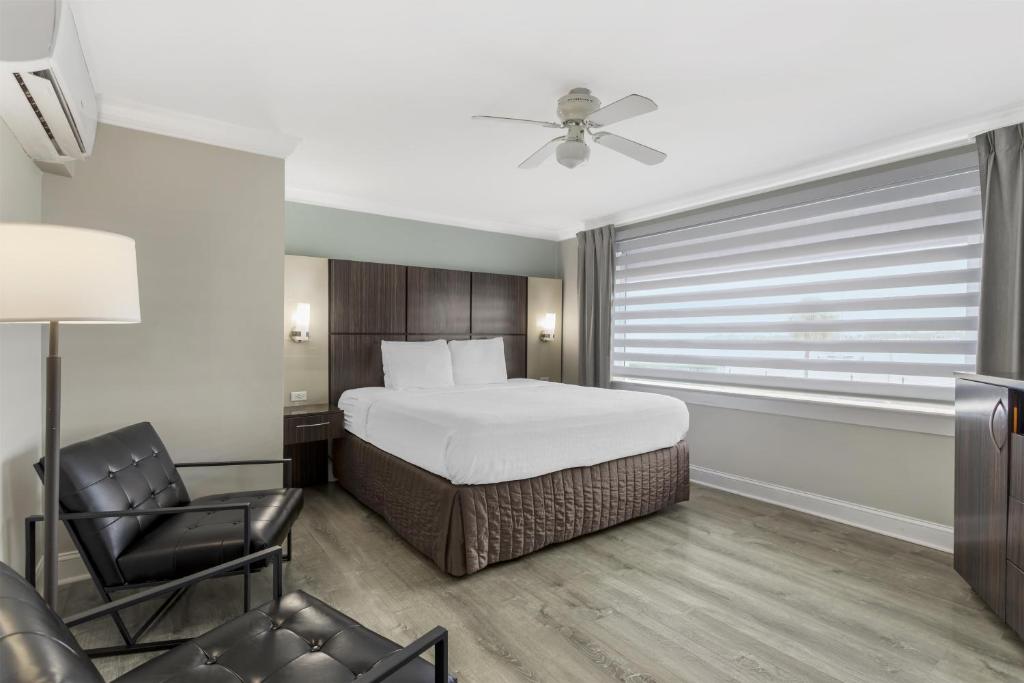 a bedroom with a bed and a chair and a window at Best Western Historic Bayfront in St. Augustine