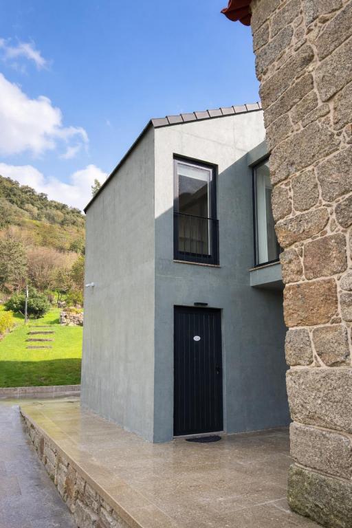 a house with a black door on the side of it at Ermida Vista Douro in Baião