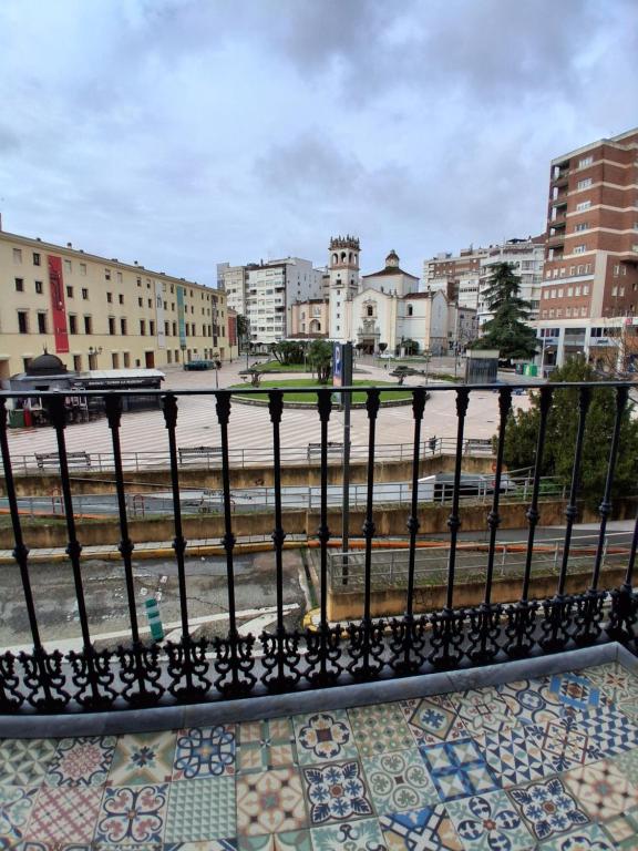 a black fence in a city with buildings at San Atón apartamentos in Badajoz