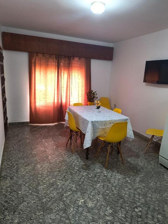 a dining room with a table and yellow chairs at Alojamiento casa amueblada in Villa María