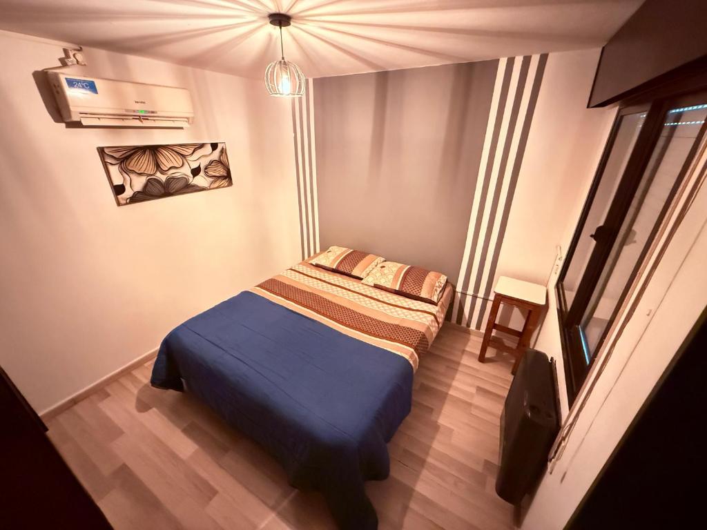 a bedroom with a bed with a blue blanket in it at Bicentenario Alem in Villa María