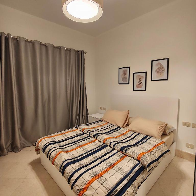 a bedroom with a bed with a blanket on it at OrientalCoast in Quseir