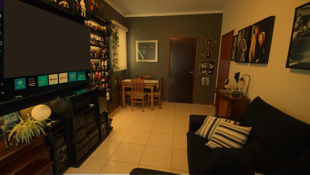 a living room with a television and a dining room at Apartamento Centro São Carlos in São Carlos