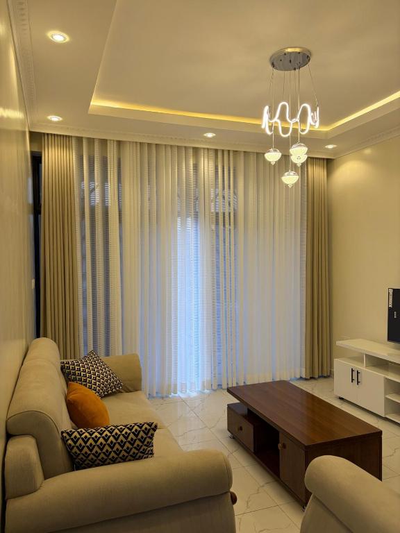 Una sala de estar con un sofá y una mesa de café. en CityGlow Apartment, en Kigali