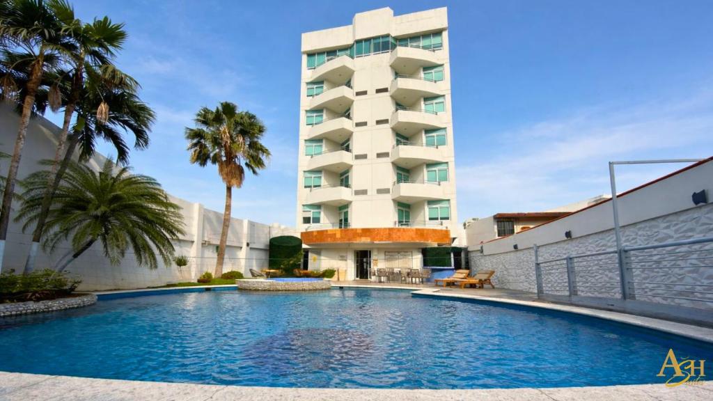a swimming pool in front of a building at Angeles Suites & Hotel in Veracruz