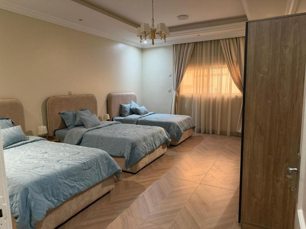 a bedroom with three beds and a window at رحاب قريش in Al Masfalah