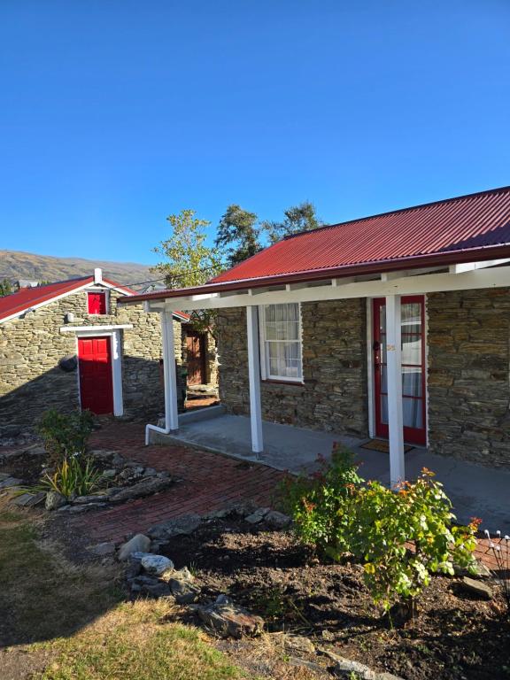 an old stone house with a red roof at Dalton's Deed in Roxburgh