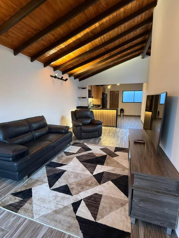 a living room with a couch and a table at Nido de Montaña Cabañas in Bello