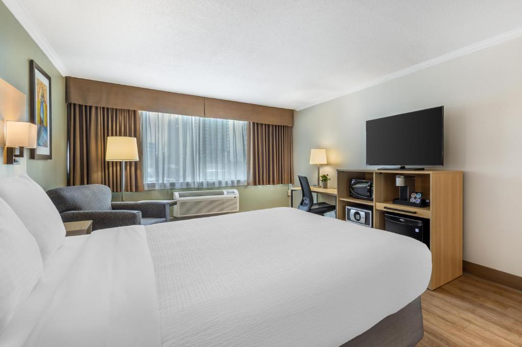 a hotel room with a bed and a flat screen tv at Best Western Plus Ottawa City Centre in Ottawa