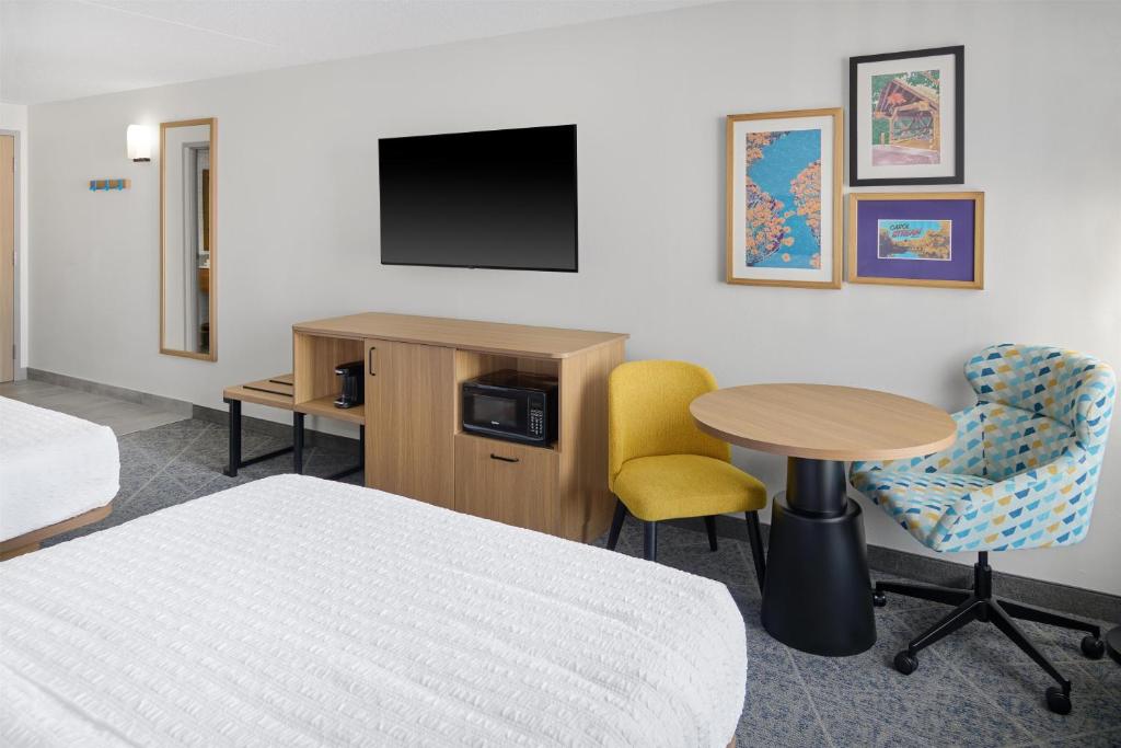 a hotel room with a bed and a table and a tv at Hampton Inn Chicago-Carol Stream in Carol Stream