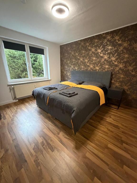 a bedroom with a bed and a wooden floor at Home4You Hamburg-Neugraben EG in Hamburg