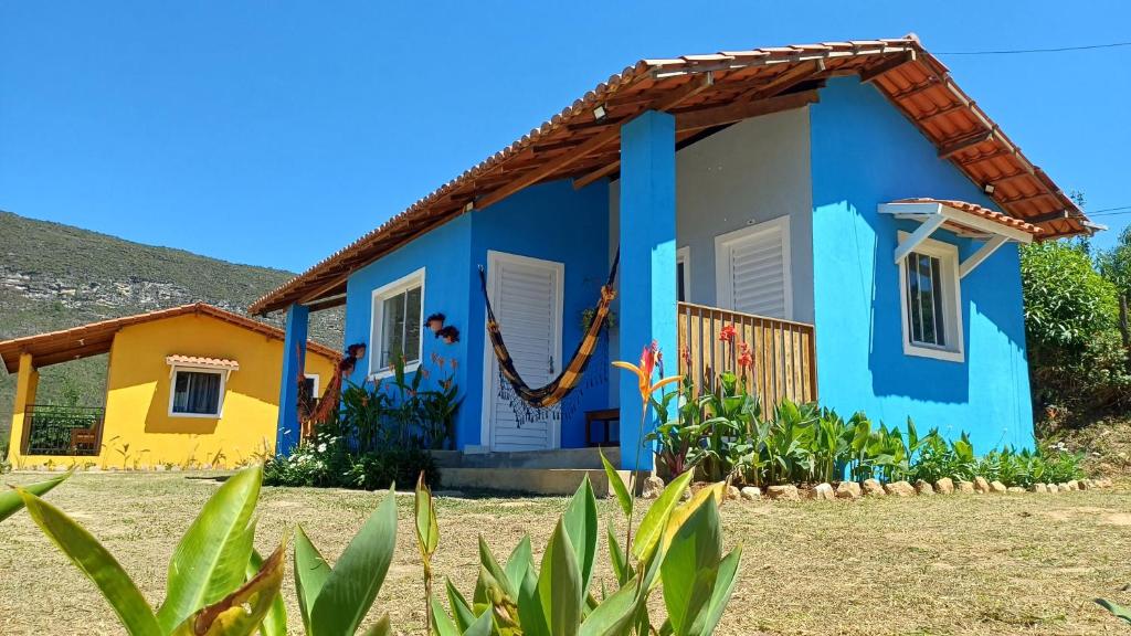 a house with a blue and yellow house at Chalés Canto da Graúna in Ibicoara