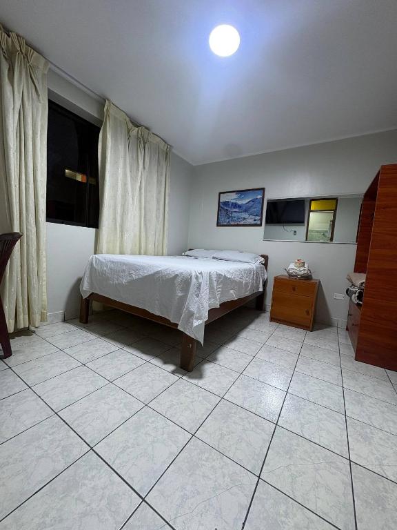 a bedroom with a bed and a tiled floor at Hospedaje W TAWA in Lima