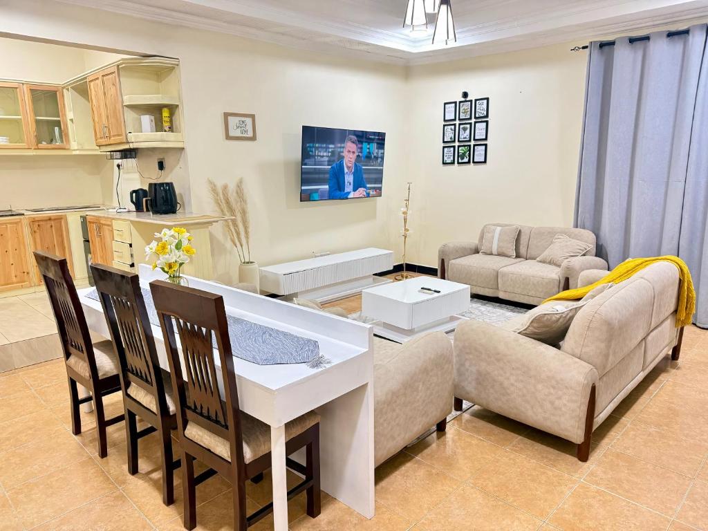 a kitchen and living room with a table and chairs at Jefes Haven in Dar es Salaam
