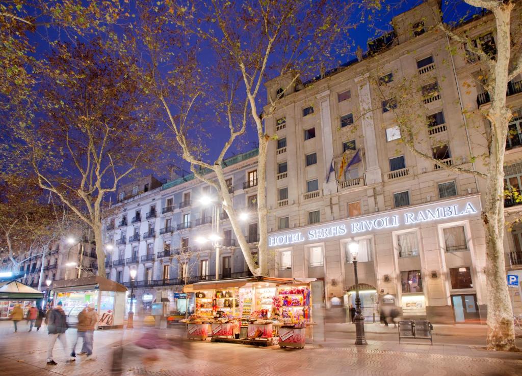 a city street at night with a market in front of a building at Hotel SERHS Rivoli Rambla in Barcelona