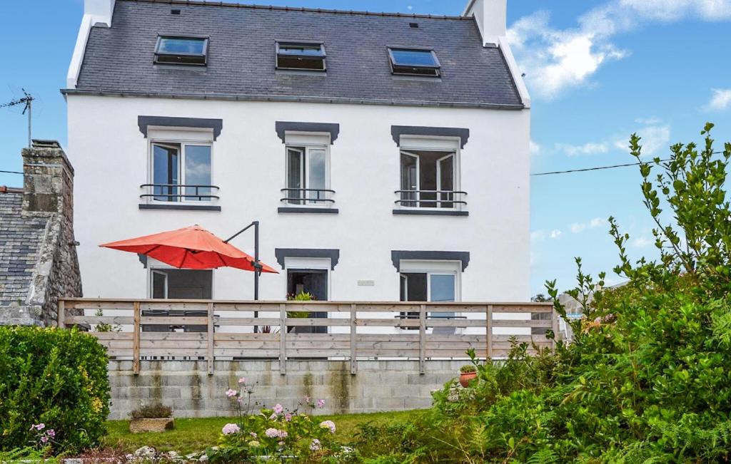 a white house with a red umbrella in front of it at Kerarmoor in Plouhinec
