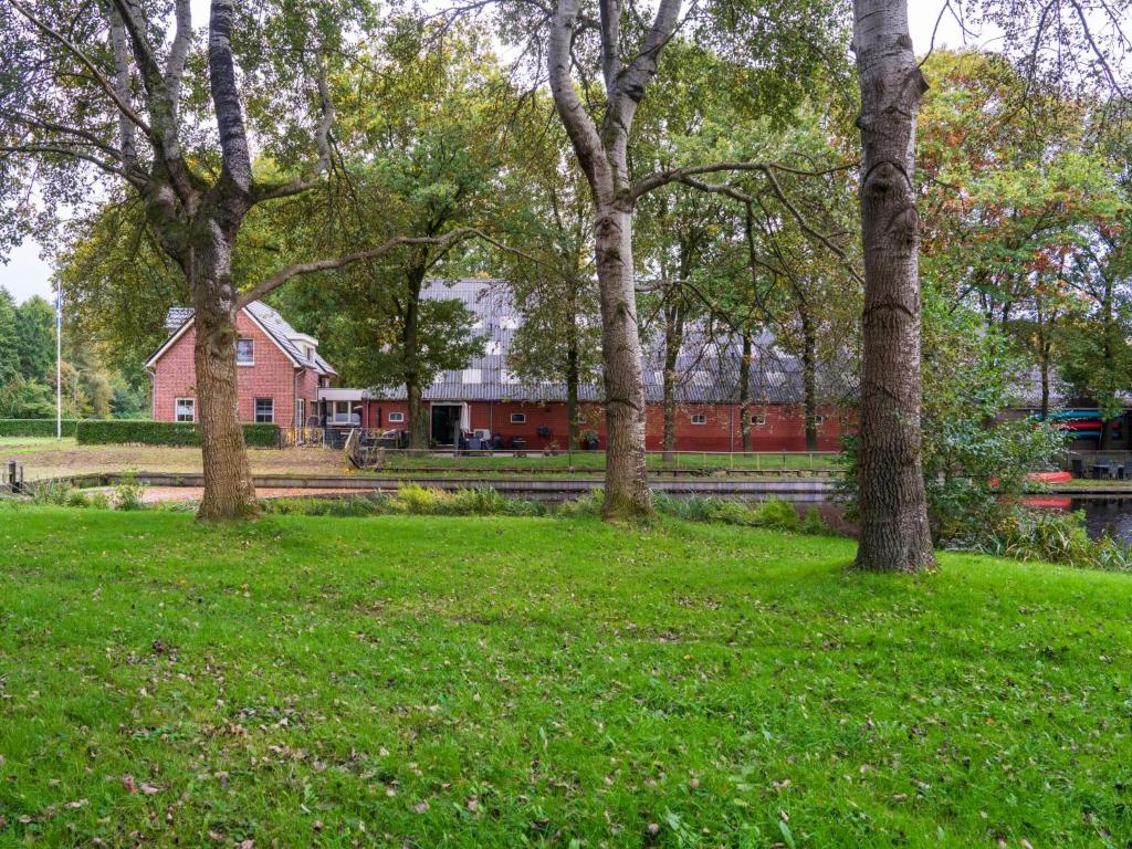 a red barn in the middle of a field with trees at Rutershoeske in Veendam
