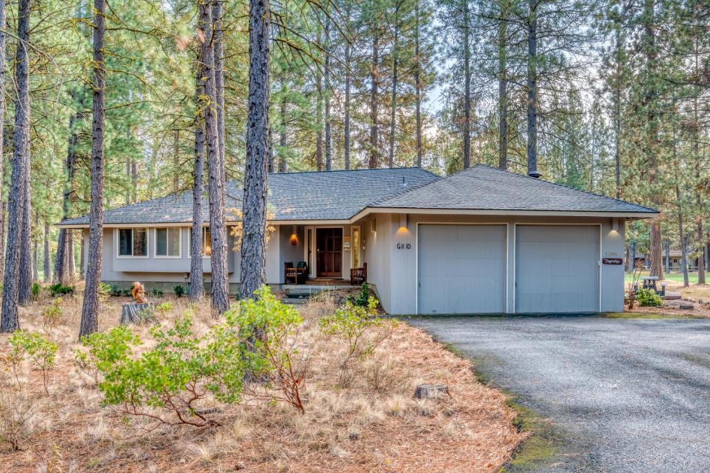 a house with a garage in the woods at Golf Home 010 in Black Butte Ranch