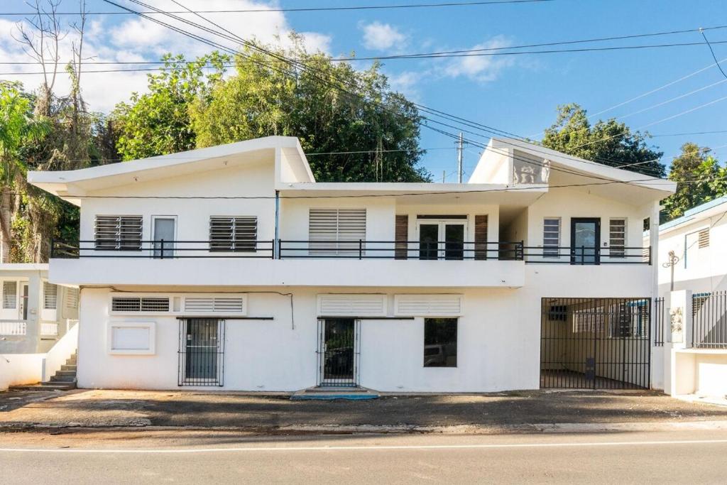 a white house with a balcony at Casa Norma in Mayaguez in Hacienda Constanza