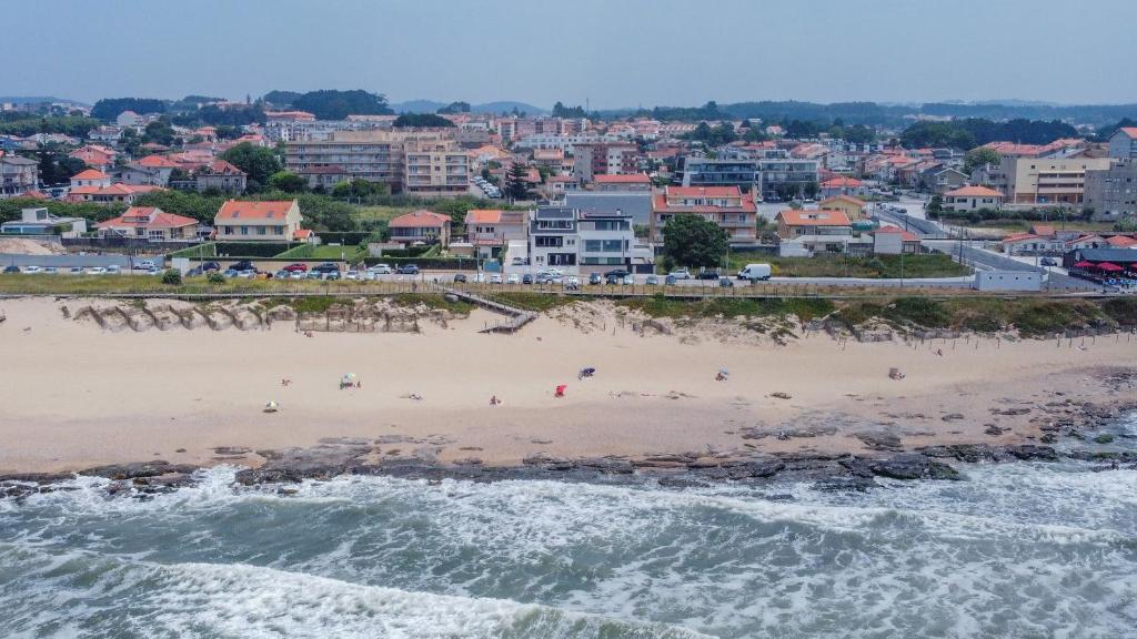 a view of a beach with a city in the background at Granja Beach Front in São Félix da Marinha