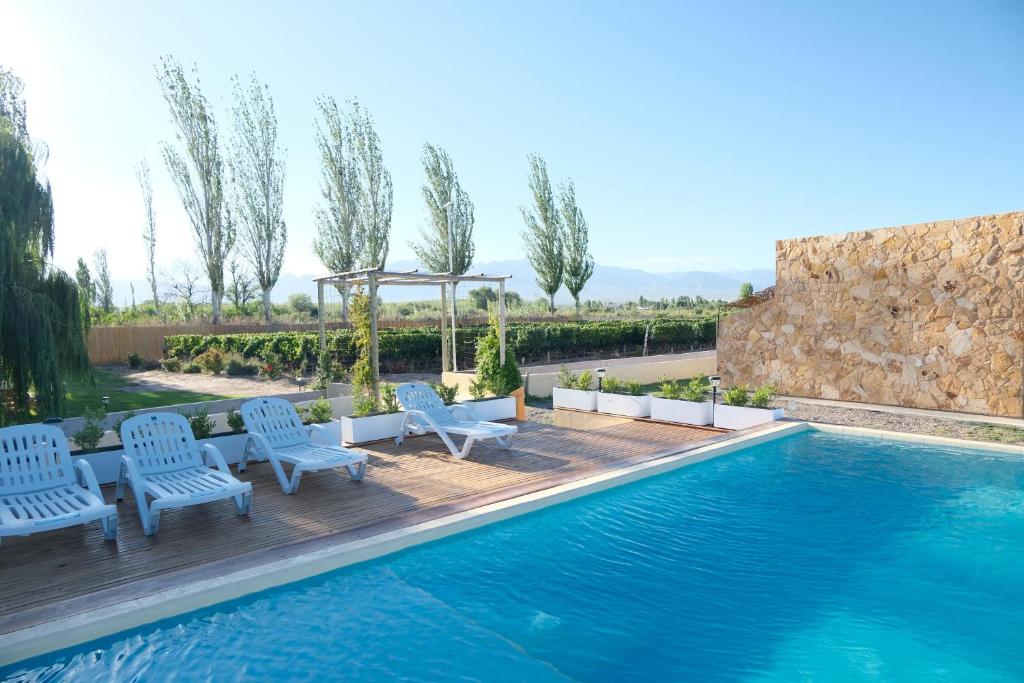 a pool with chairs and a gazebo at Rincon del Malbec in Ciudad Lujan de Cuyo