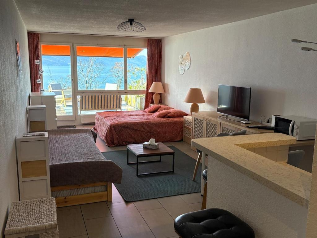 a hotel room with a bed and a television at Cozy studio in Veytaux