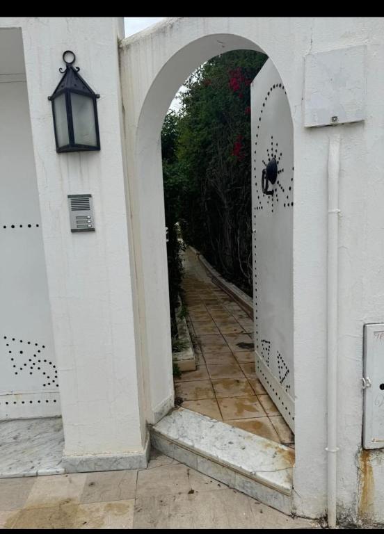 an entrance to a white building with a white door at Appartement rez de jardin in Hammamet