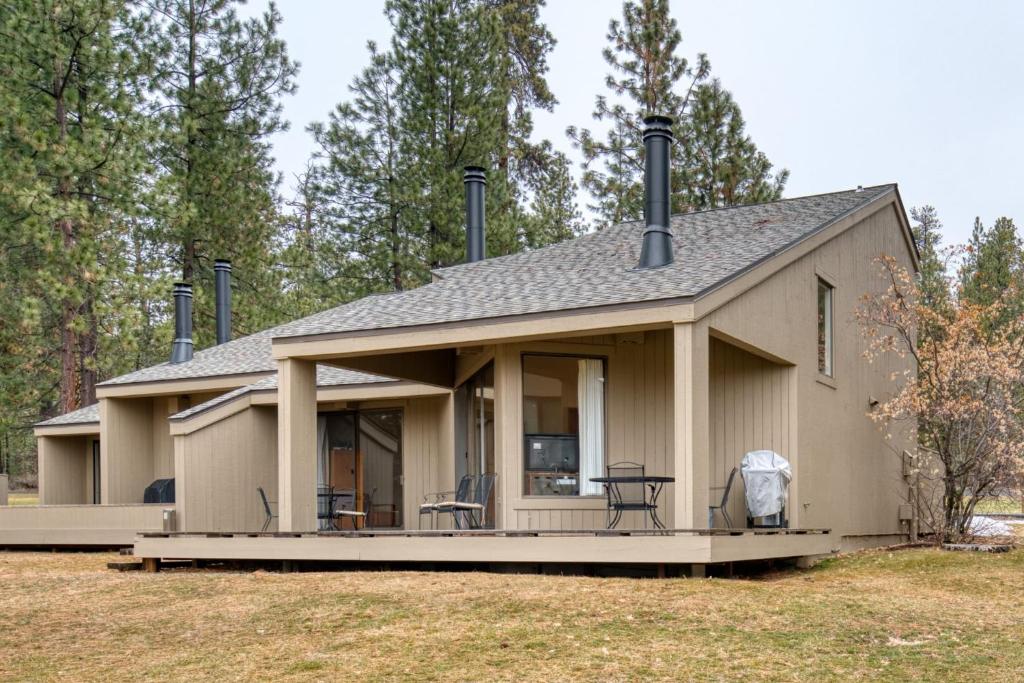 a house with a porch with chairs on it at Lodge Condo 014 in Black Butte Ranch