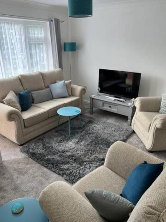 a living room with two couches and a tv at El Sea House in Chapel Saint Leonards