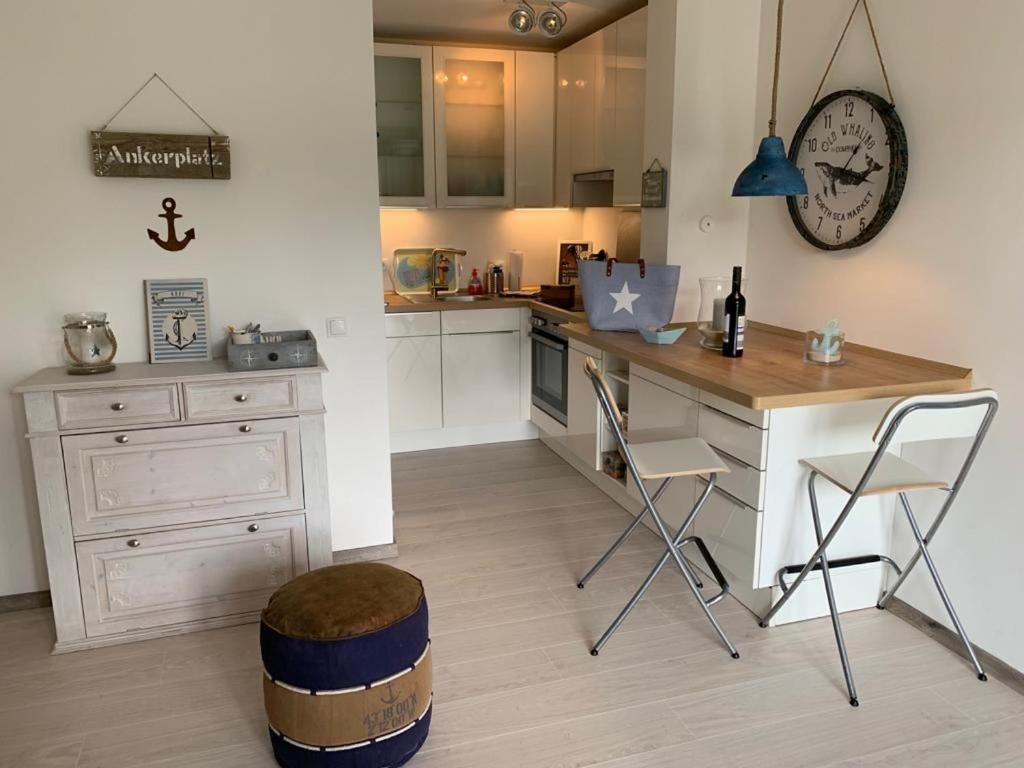 a kitchen with a desk and chairs and a clock at Kleine Auszeit in Garding