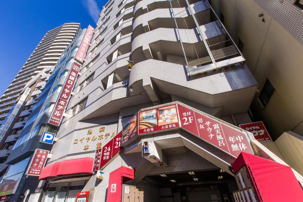 a tall building with red and white signs on it at Ikebukuro Royal Hotel in Tokyo