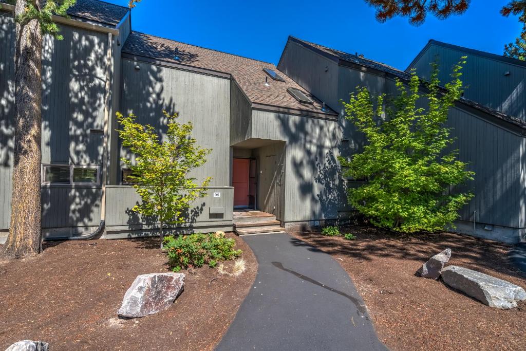 a home with a gray building with trees and rocks at Golf Condo 095 in Black Butte Ranch