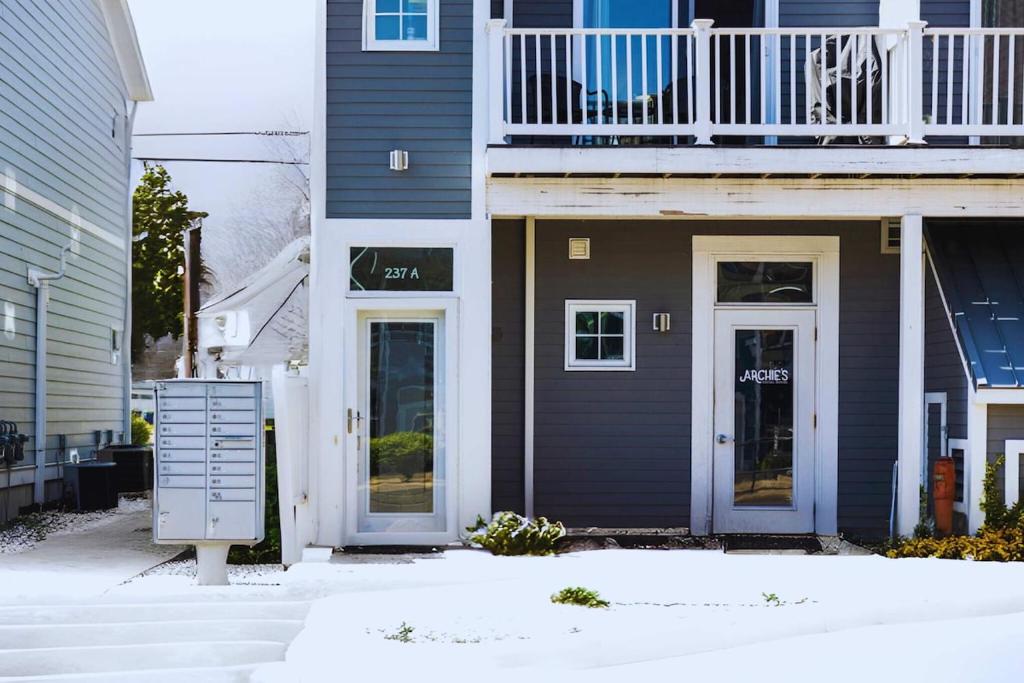 a house with blue doors and a balcony at Midcentury Getaway: Walk to Everything! in Traverse City