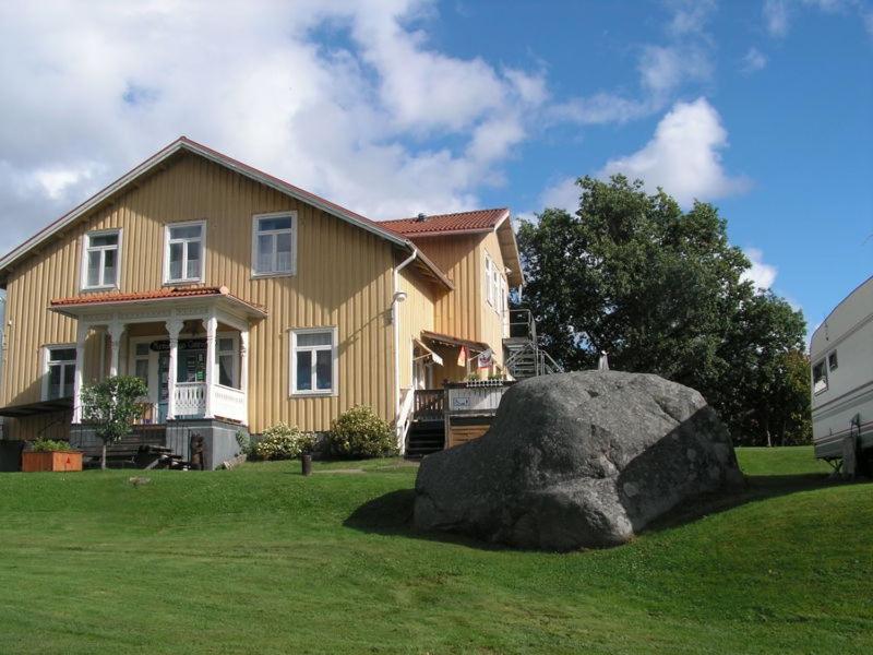 uma casa com uma grande pedra em frente em Munkebergs Stugor & Vandrarhem em Filipstad