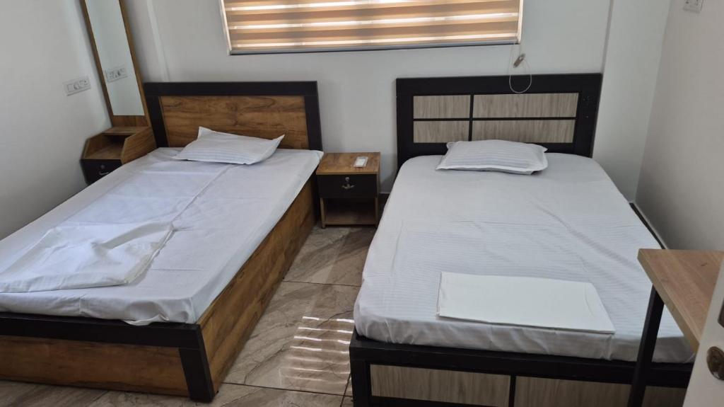 two beds in a small room with two tables at D3 Homes in Jāmb
