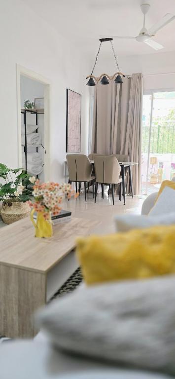 a living room with a table and a dining room at Nala Host - 2BR Garden Home in Hulhumale