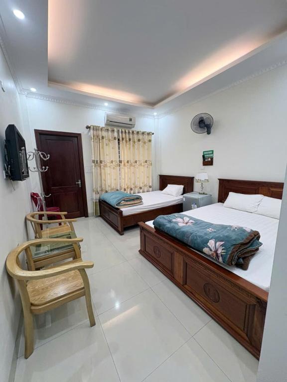a bedroom with two beds and a chair in it at Ninh Binh Friendly Hotel in Ninh Binh