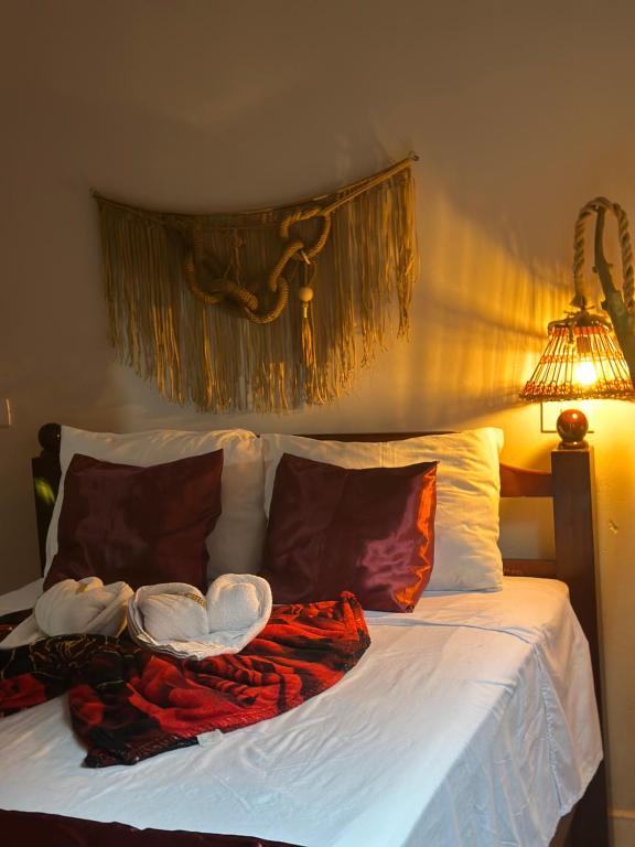 a bedroom with a bed with two pillows and a lamp at Pousada Moranga in Carolina