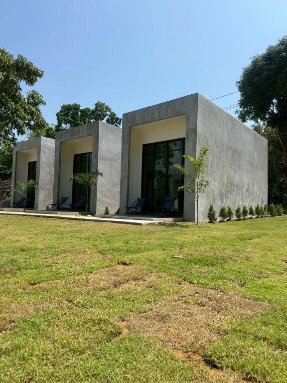 a concrete house with a grassy field in front of it at Pearlix Koh Mook in Ko Mook