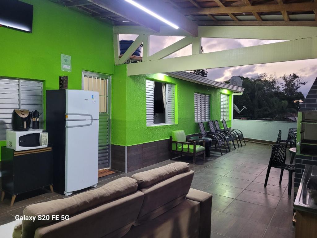 a room with a green wall with a refrigerator at Pousada do Sossego Mar e verde 3 in Itanhaém
