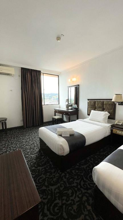 a hotel room with two beds and a desk at Swing & Pillows - Bandar Kuantan in Kuantan