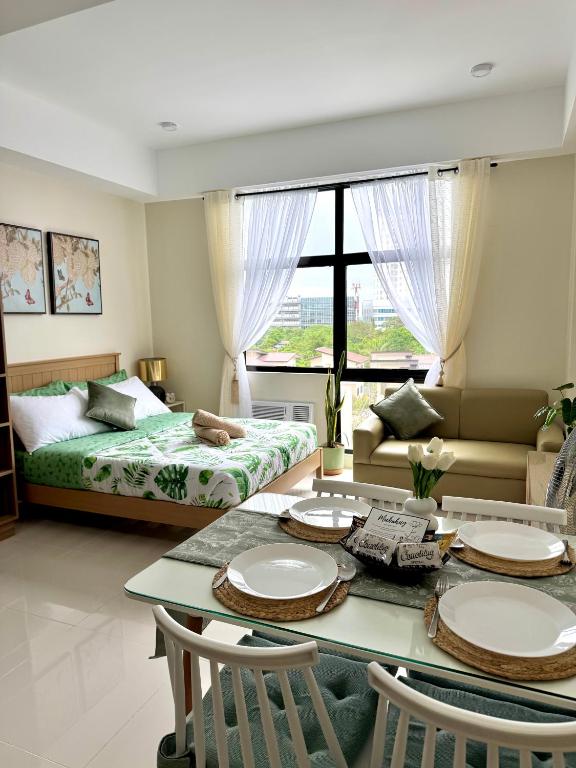 a living room with a table and a bed at Mactan Plains Residences in Mactan