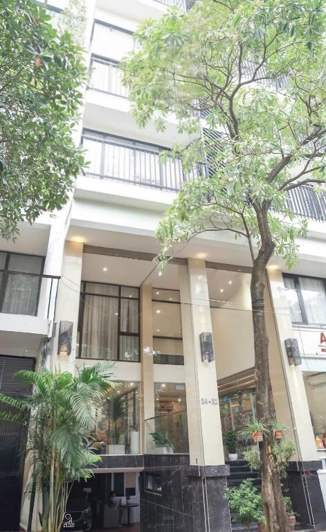 a building with a tree in front of it at Wins Apartment in Hanoi