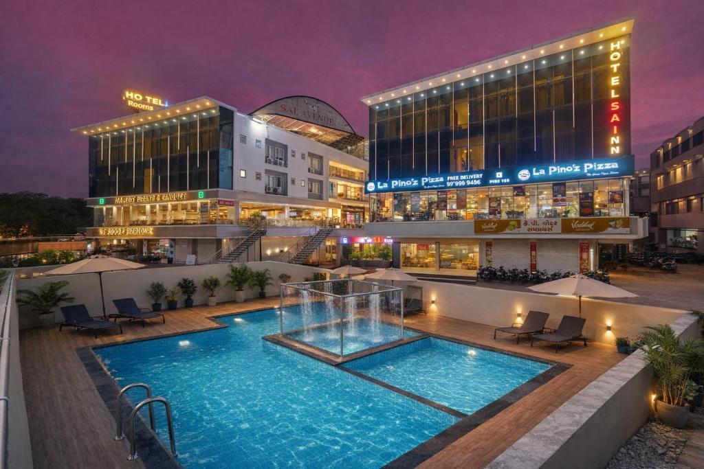 a hotel with a swimming pool in front of a building at Hotel Sai Inn at Statue of Unity in Rājpīpla