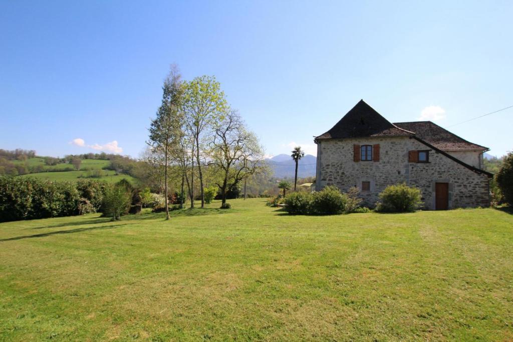 an old stone house on a green field at Maison poumarou in Sainte-Colome