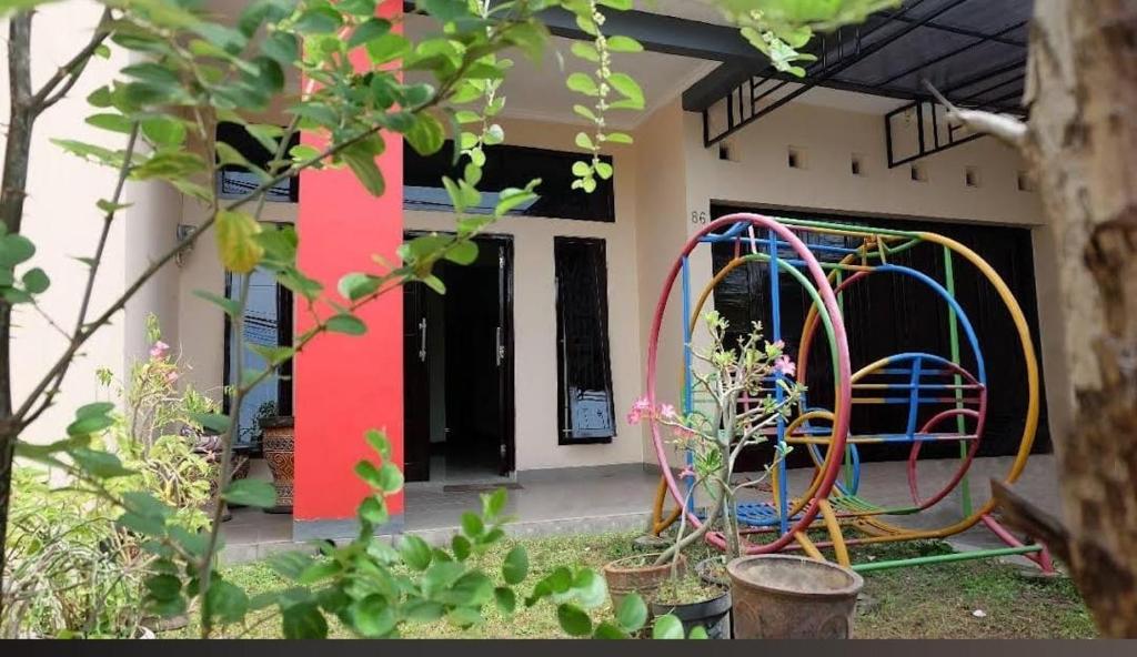 a house with a colorful playground in front of it at Homely Guest House Tegal in Tegal