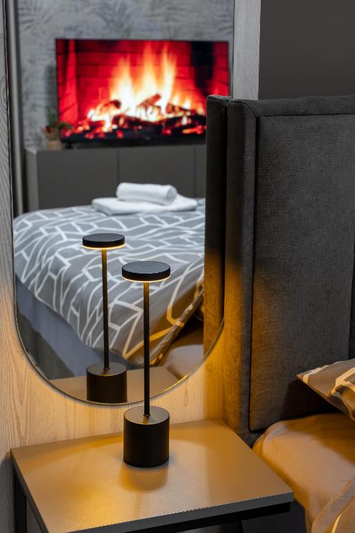 a bedroom with a bed with a fireplace in the background at Apartman Elite Stay Doboj in Doboj