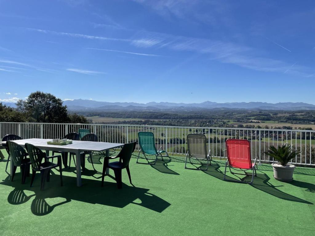 a patio with a table and chairs on a deck at Gite du coos in Audaux
