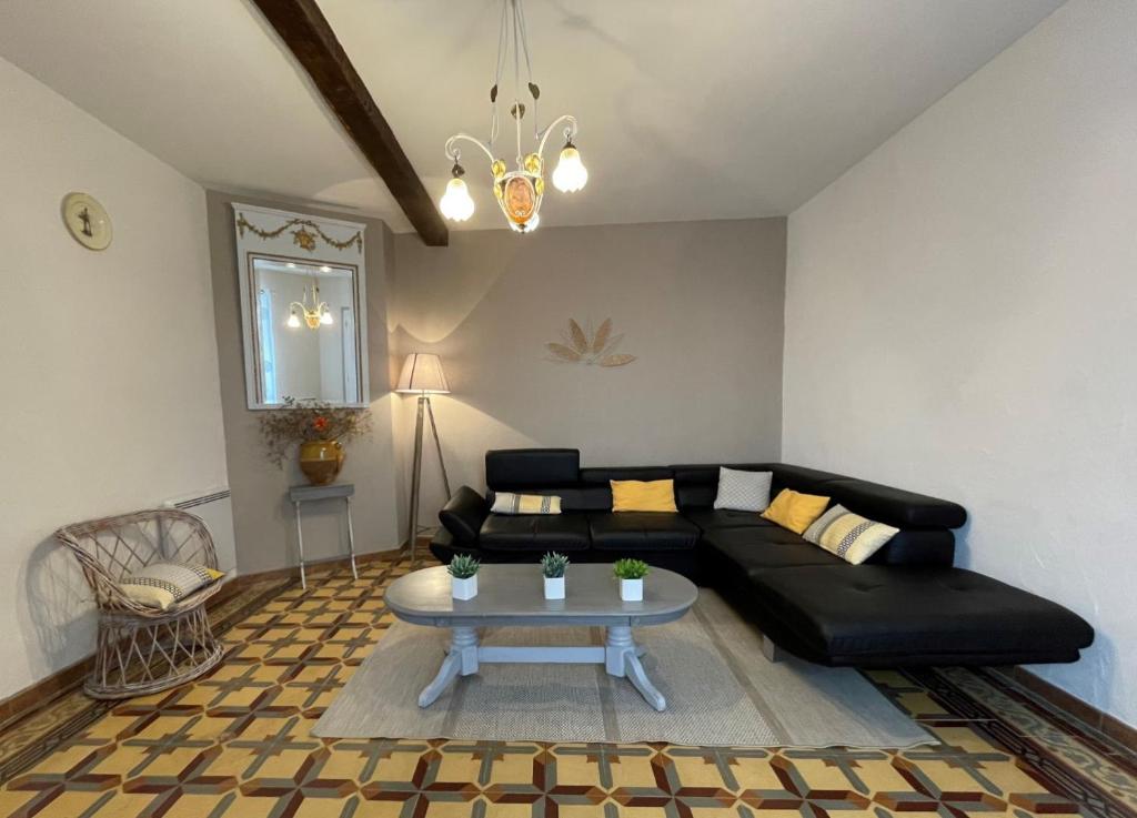 a living room with a black couch and a table at Chez file in Séméacq-Blachon