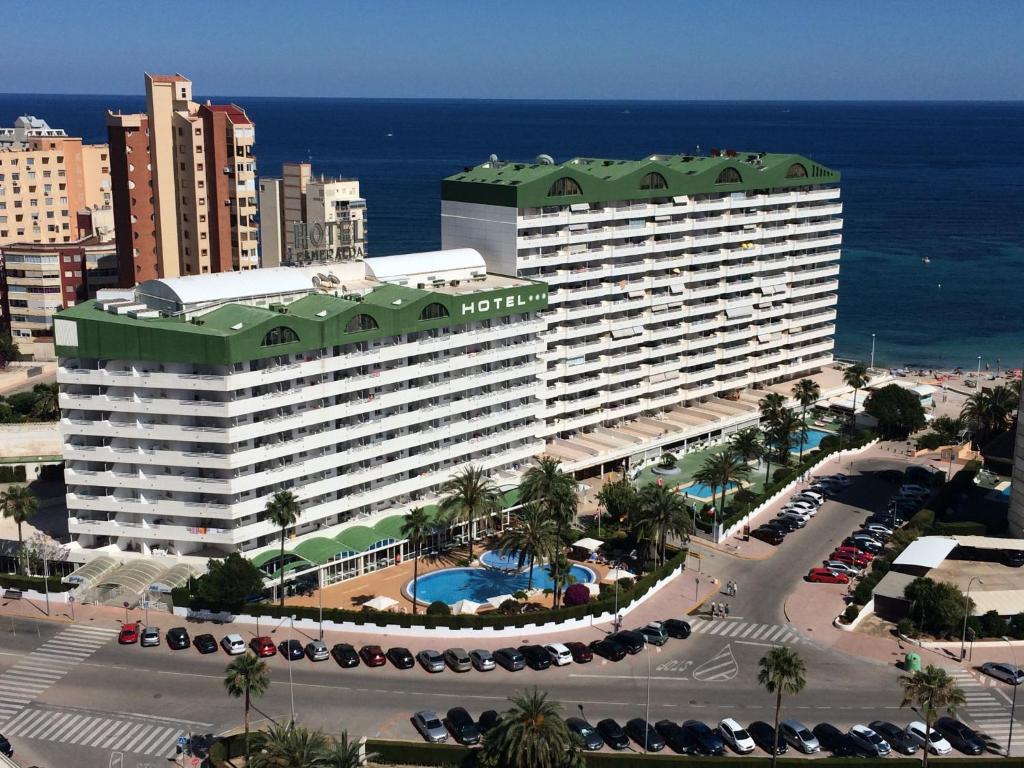 a large hotel with a parking lot in front of the ocean at AR Roca Esmeralda & SPA Hotel in Calpe